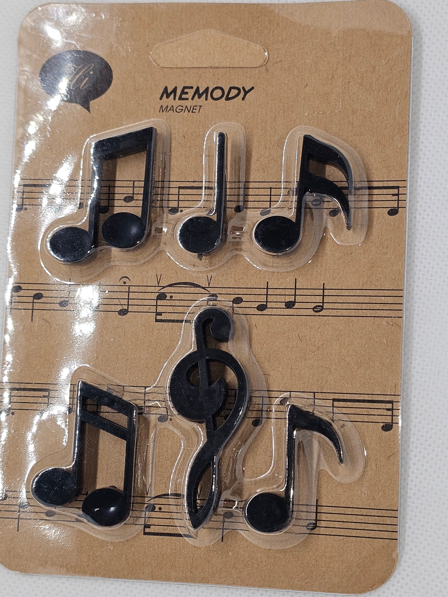 Set of black music note magnets on a cardboard backing with sheet music design