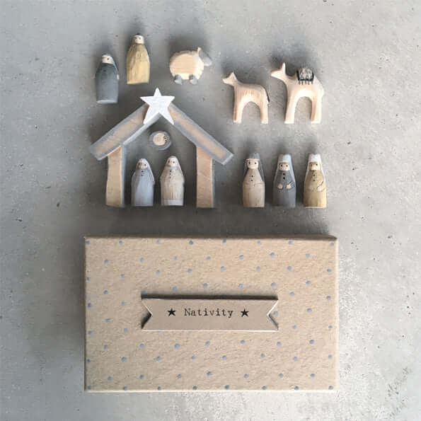 Wooden nativity set with stable on a gray background