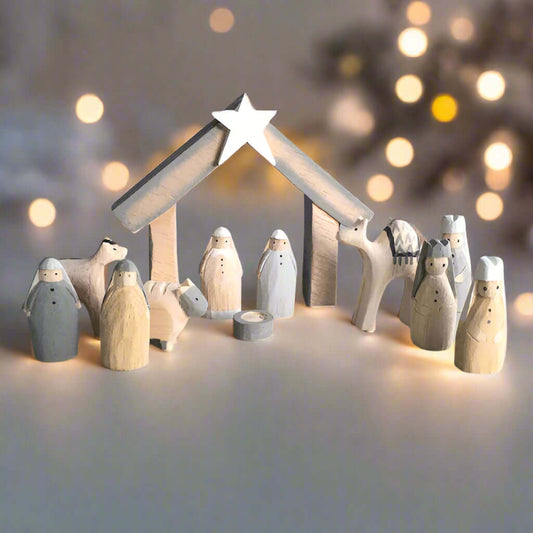 Wooden nativity set with stable and star on a light gray background