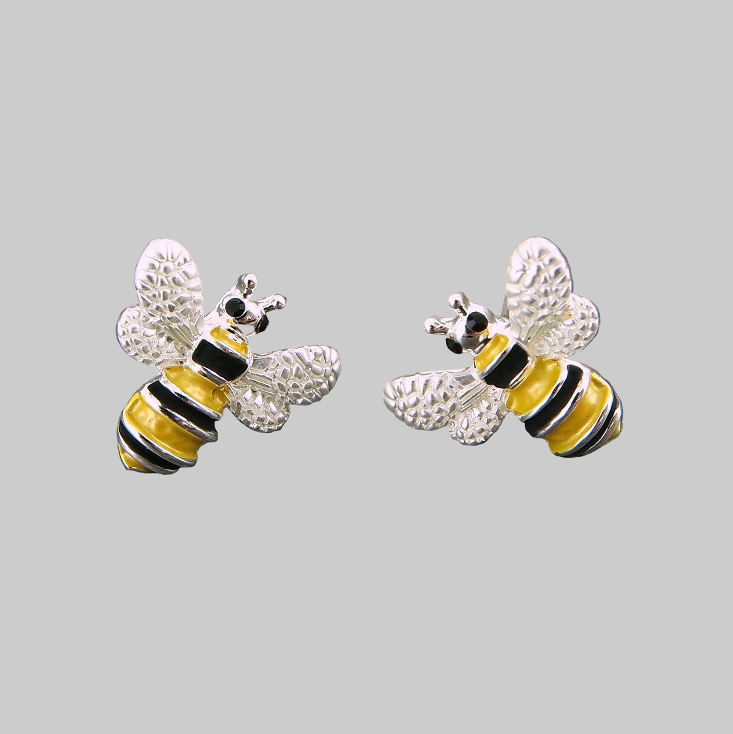 Bee-shaped earrings on a gray stone surface