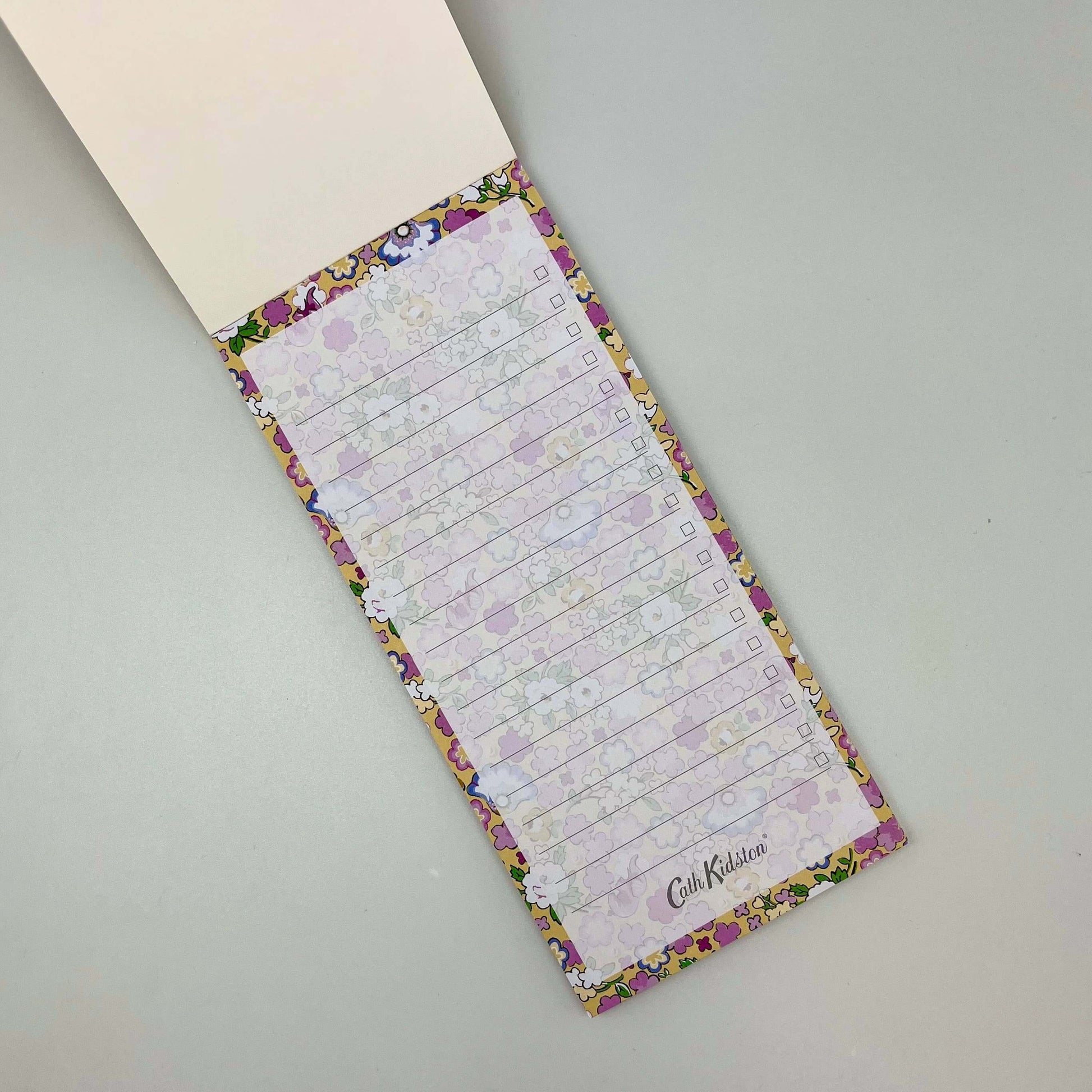 Floral-patterned notepad with checklists on a gray surface