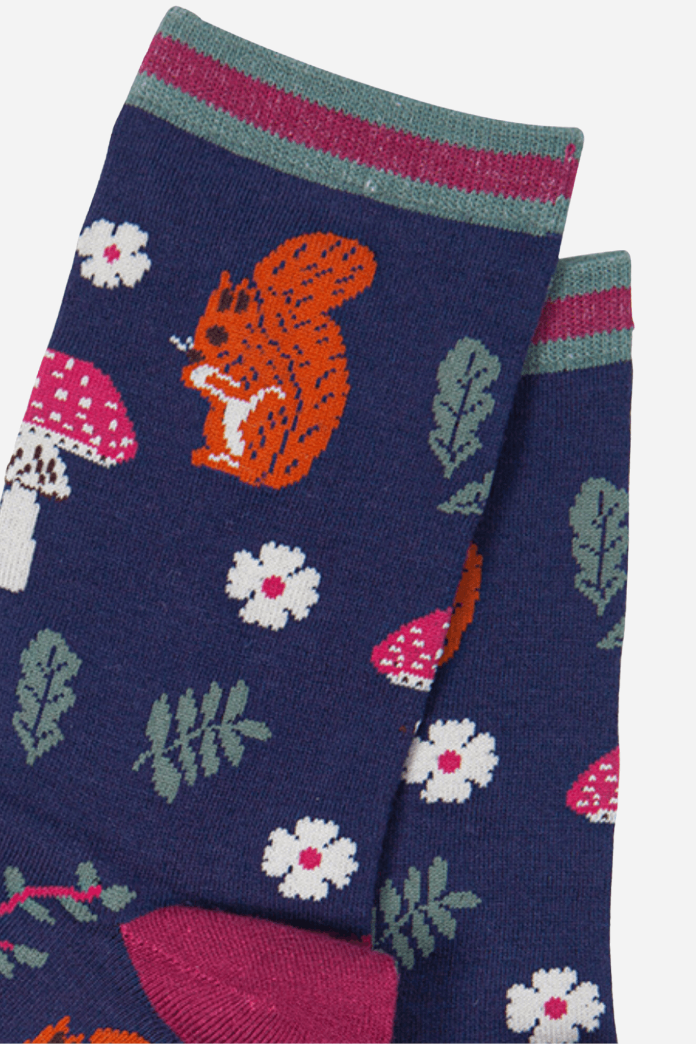 Navy blue sock with orange squirrel, pink mushrooms, and white flowers on a white background