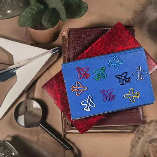 20 airplane shaped paper clips in a tin.