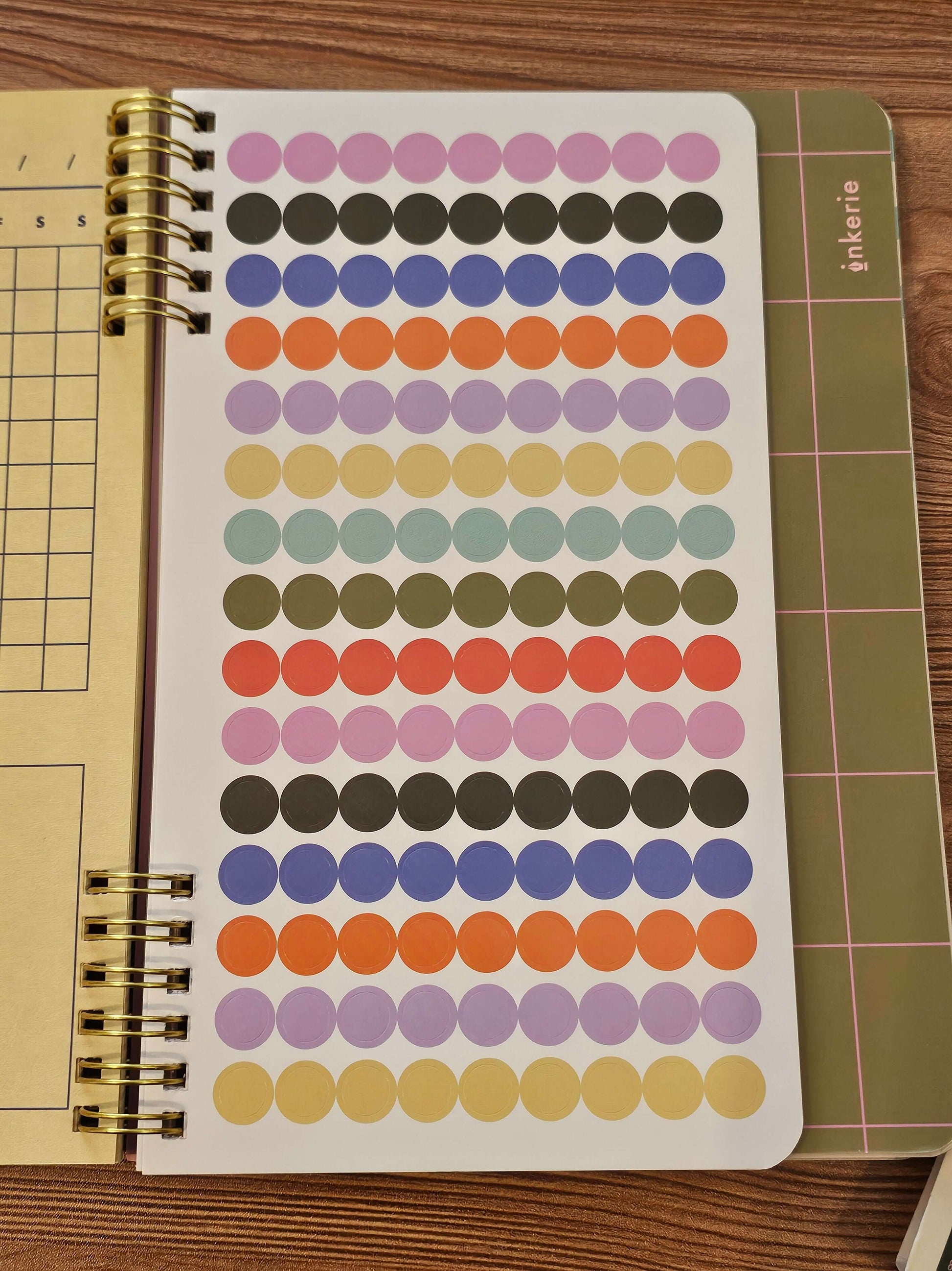 Colorful dot stickers in a spiral-bound notebook for tracking habits and goals.