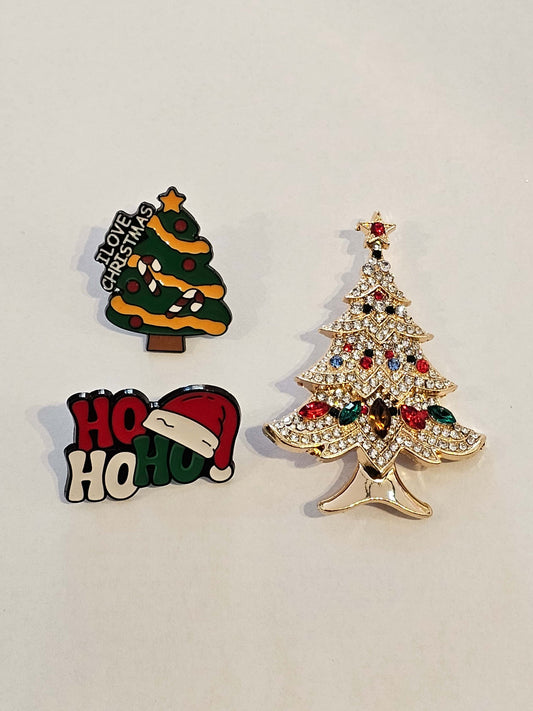 Three Christmas-themed pins on a light gray background