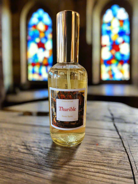 Bottle of room spray on a wooden surface inside a church with a window behind it