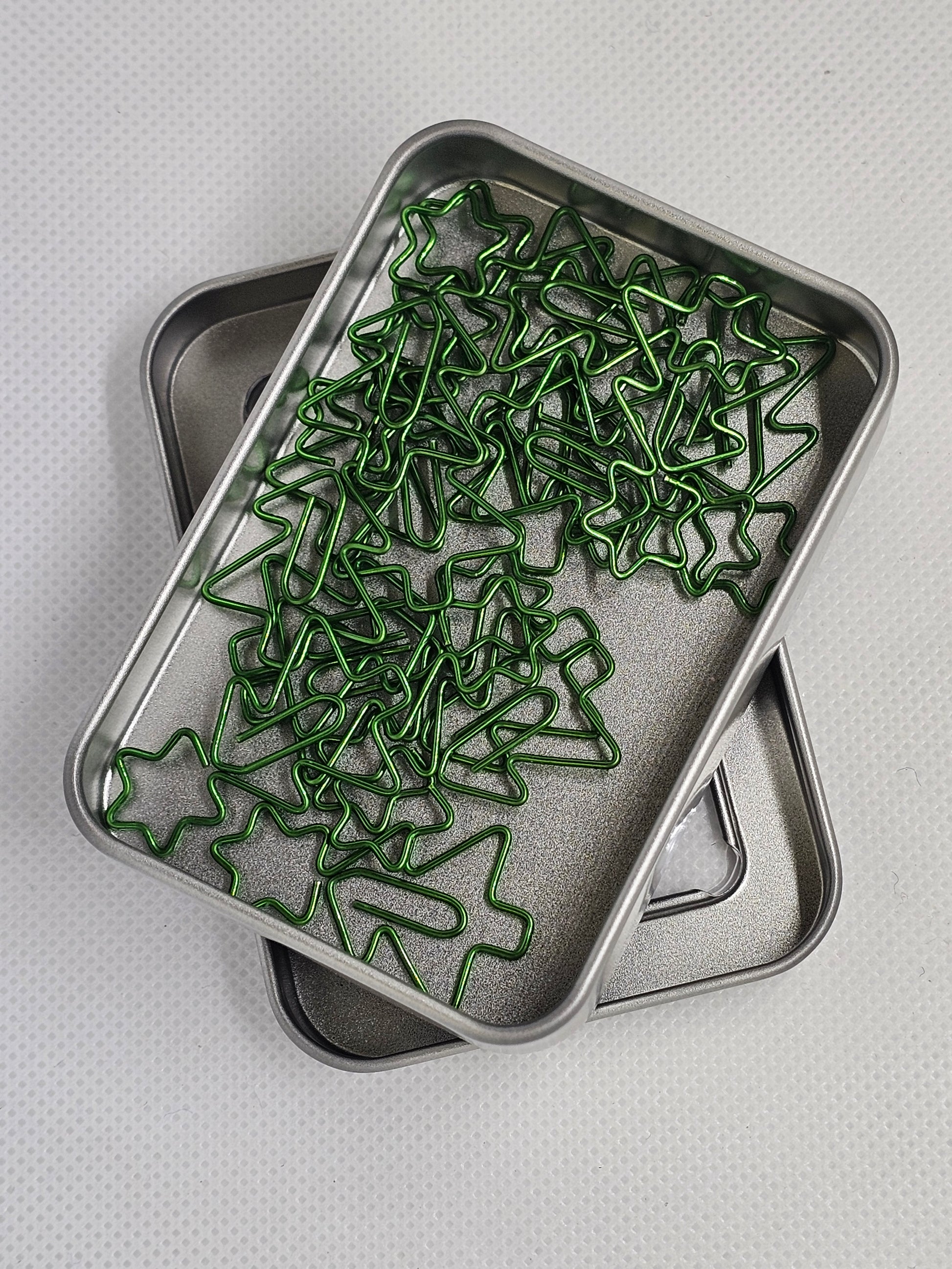 Metal tray with green star-shaped objects on a light gray background