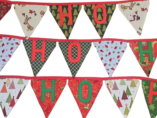 Christmas-themed fabric banner with 'HO HO HO' text on a wooden surface