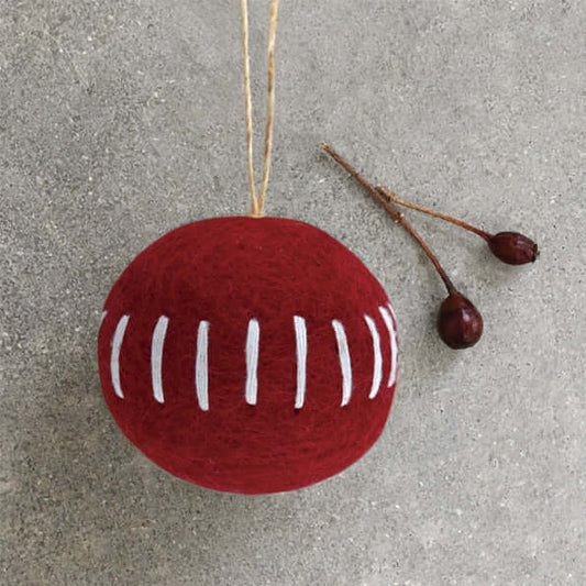 Red textured ball with white stripes on a gray surface