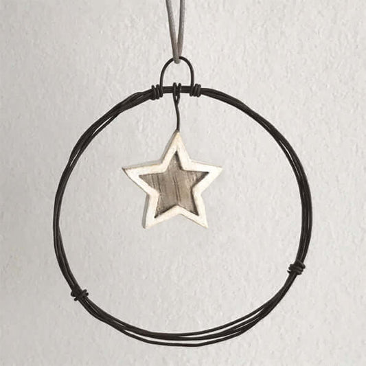 Star-shaped pendant on a black cord against a light gray background