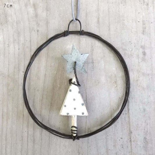 Decorative metal tree and star ornament on a wooden background