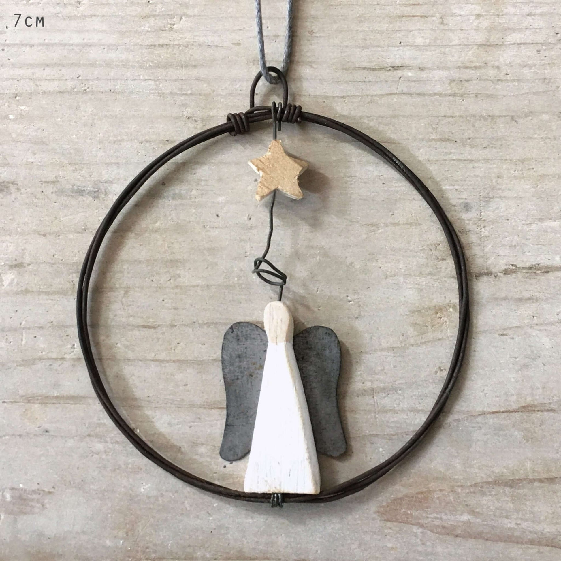 Decorative hanging with angel wings and a star on a neutral background