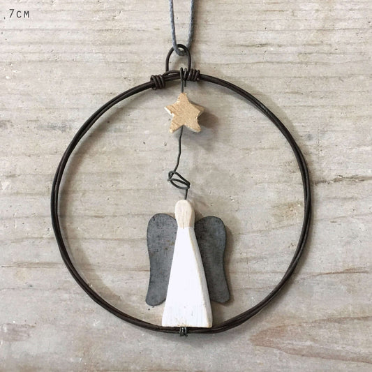 Decorative hanging with angel wings and a star on a neutral background