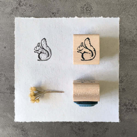 Squirrel-themed rubber stamps on a white paper with a gray background