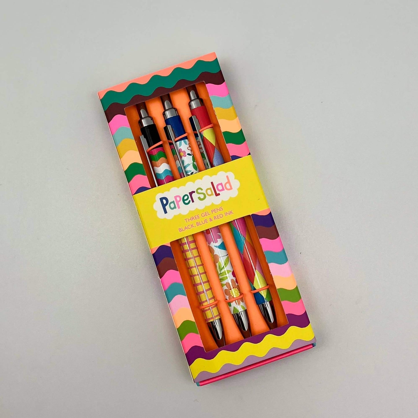 Packaged set of colorful pens with 'Paper Salad' branding on a gray background
