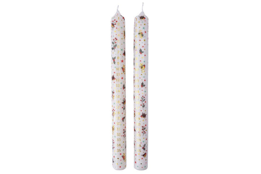 Two white candles with speckled patterns on a white background