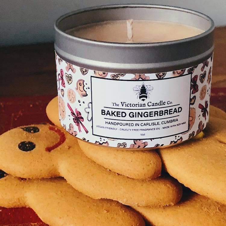 Candle in a decorative tin surrounded by gingerbread cookies