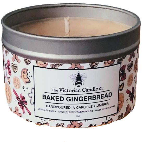 Candle in a decorative tin surrounded by gingerbread cookies