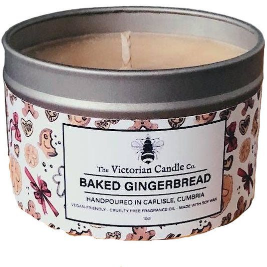 Candle in a decorative tin surrounded by gingerbread cookies