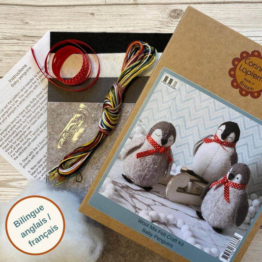 Wool mix felt craft kit for baby penguins with packaging and materials on a wooden surface.