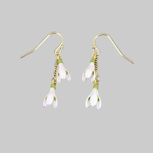 Pair of floral earrings with gold chains on a gray background