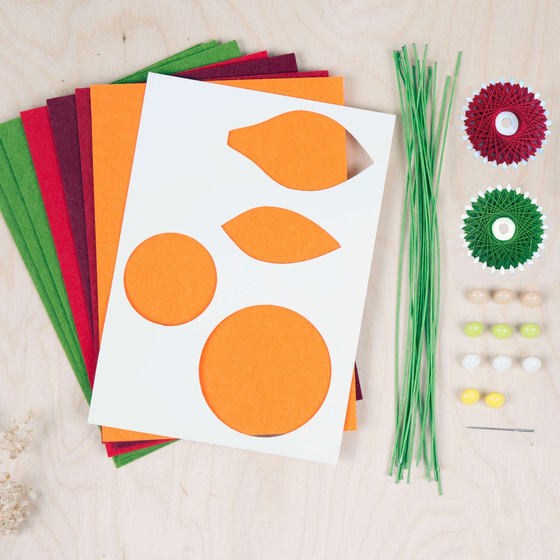 Colorful felt sheets and crafting supplies for creating a DIY felt flower bouquet by Kikkerland.