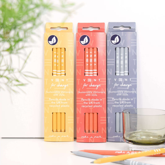 Three packs of recycled pencils in yellow, orange, and purple, showcasing sustainable stationery by VENT for change.