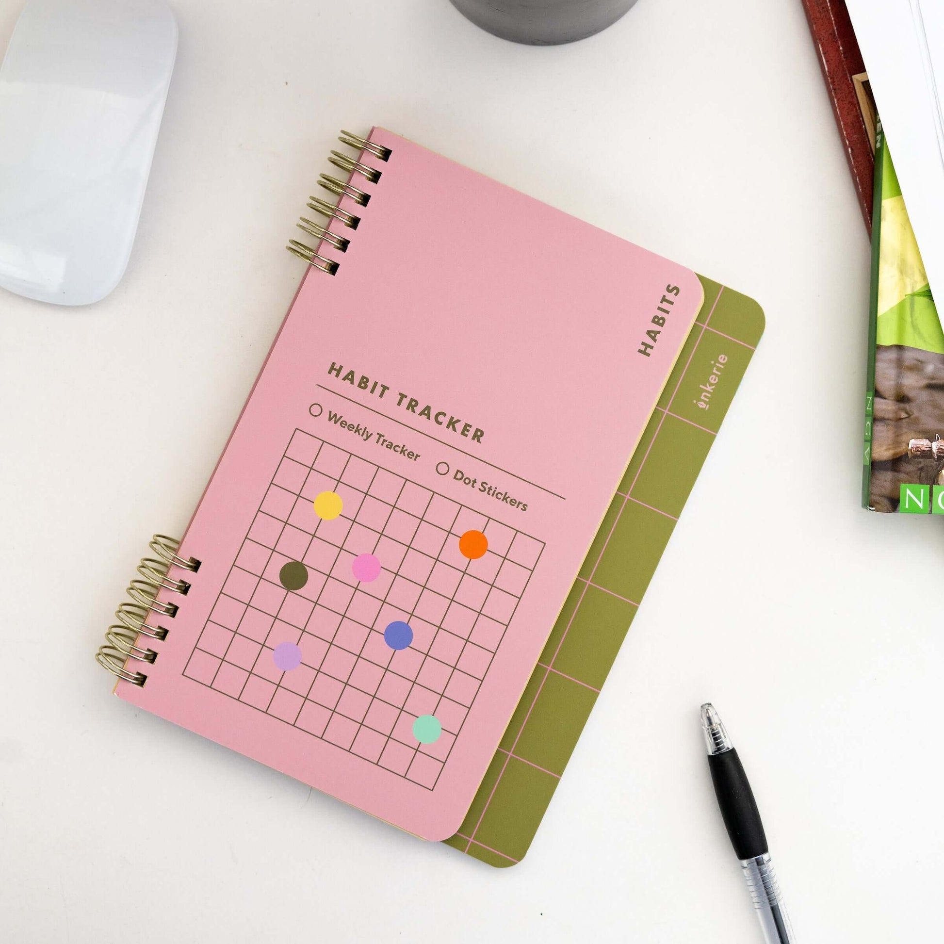 Colorful habit tracker notebook with spiral binding, weekly format, and dot stickers for goal tracking.