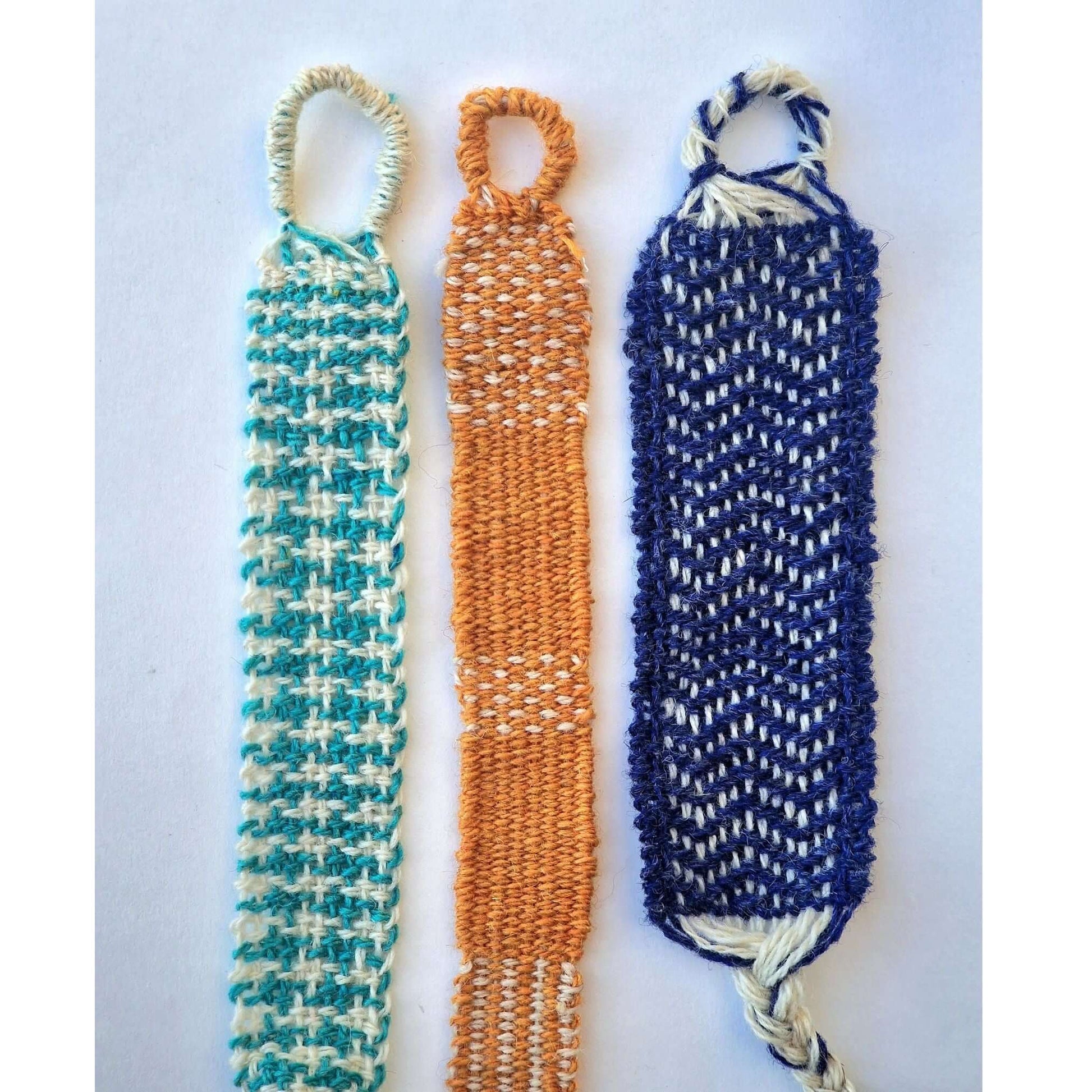 Colorful woven bracelet samples showcasing patterns created with the Rocket Loom bracelet weaving kit.