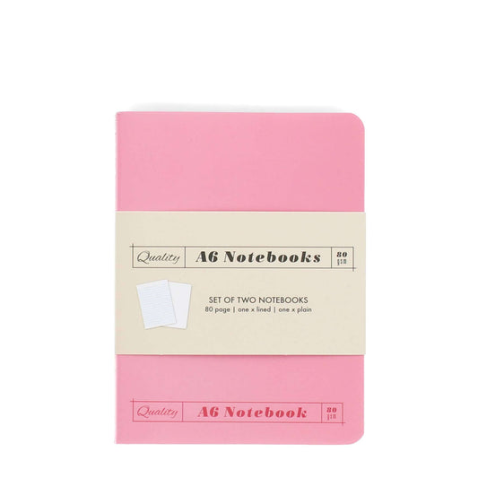 Pink A6 notebook with beige label on a white background