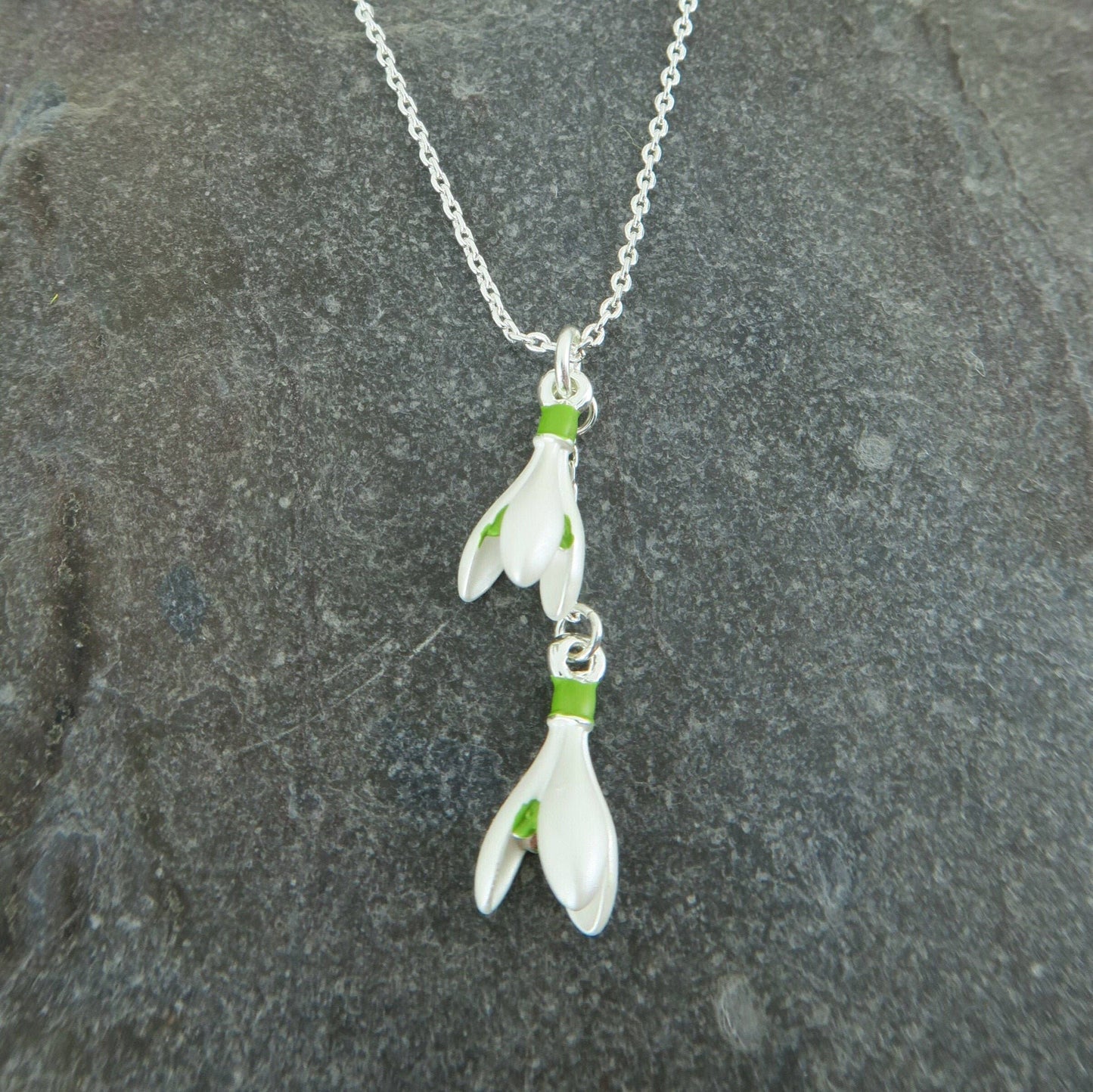 Floral pendant necklace on a chain against a stone background