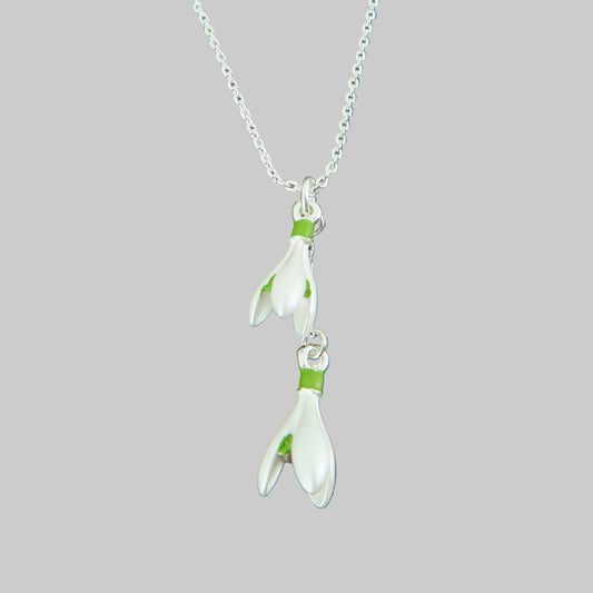 Floral pendant necklace on a chain against a stone background