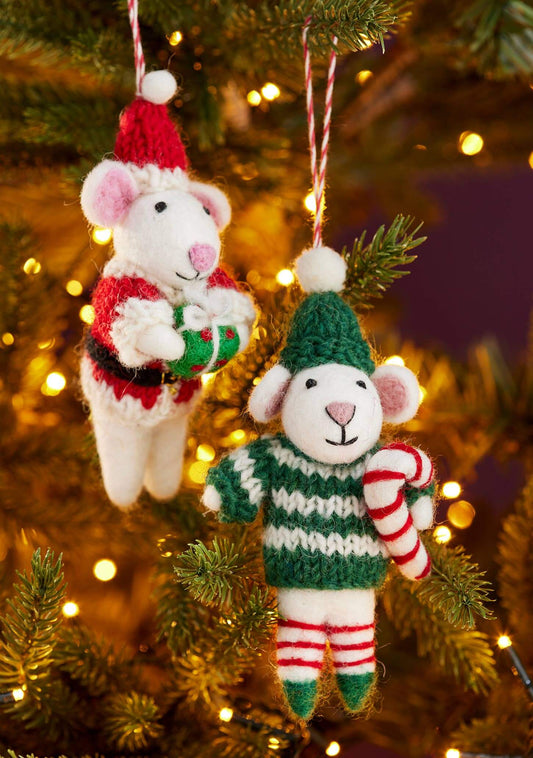 Two knitted mouse ornaments on a Christmas tree with lights in the background.