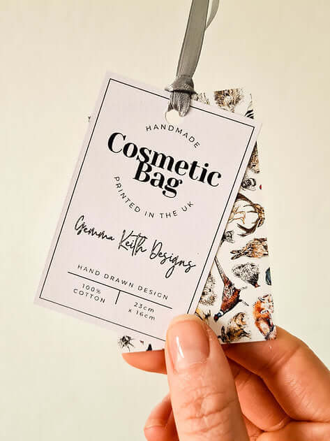Handmade cosmetic bag label held by a hand with a neutral background