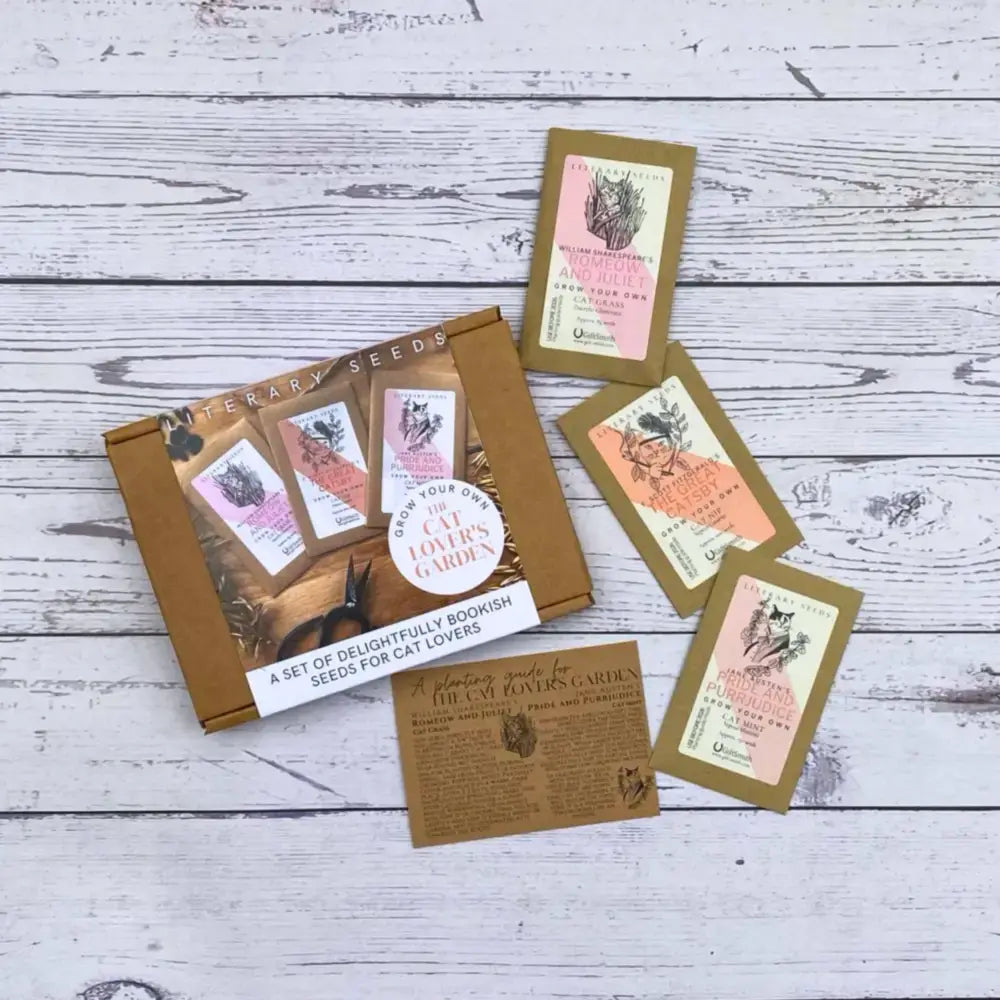 Literary Seeds: The Cat Lover's Garden seed packets displayed on a wooden surface, perfect for cat lovers and book enthusiasts.