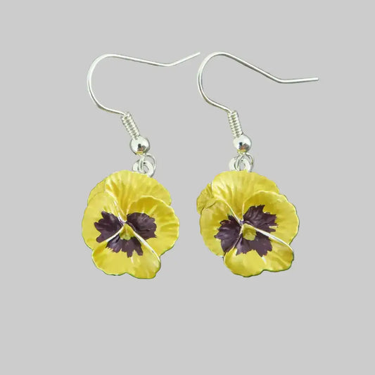 Yellow flower earrings with silver hooks on a gray background