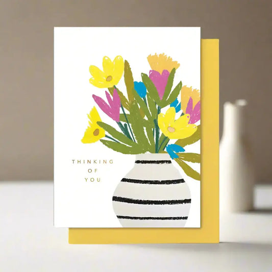 A beautiful card with  vase and flowers on it. With the words 'Thinking of you'