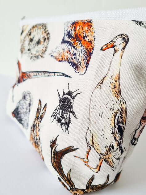 Fabric with nature-themed design featuring animals and a bee on a white background