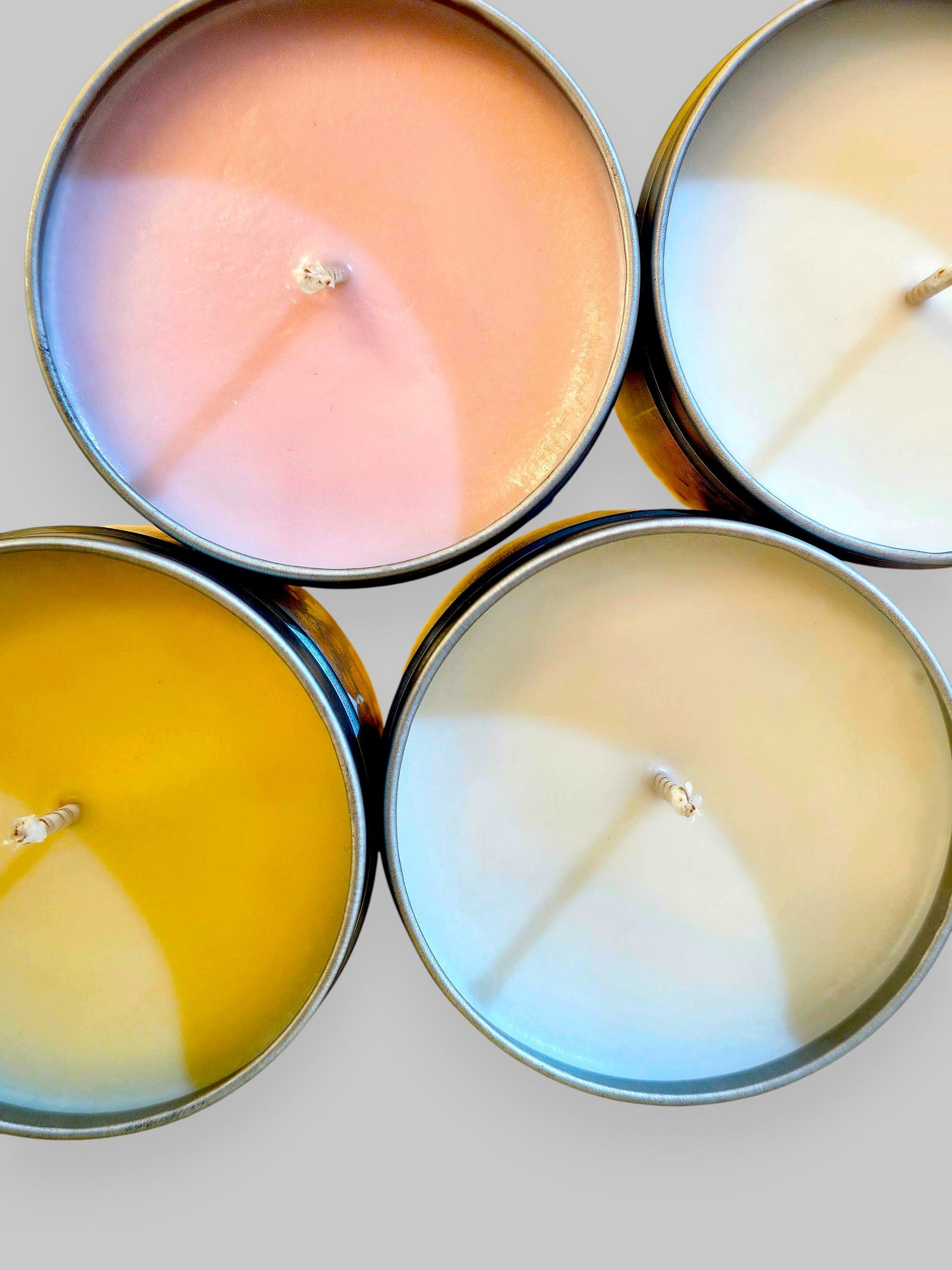 A collection of beautifully scented candles including Orange Zest, displayed on a wooden shelf.
