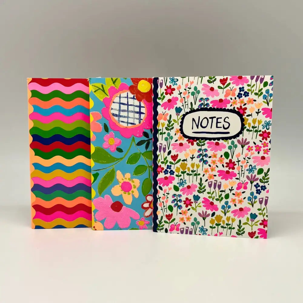 Colorful notebooks with floral designs and vibrant patterns, perfect for jotting down notes.