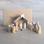 Wooden nativity set with stable and figures on a gray surface