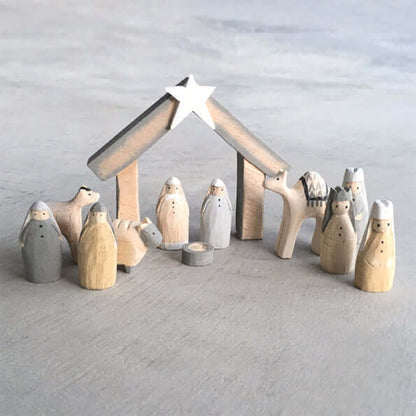 Wooden nativity set with stable and star on a light gray background