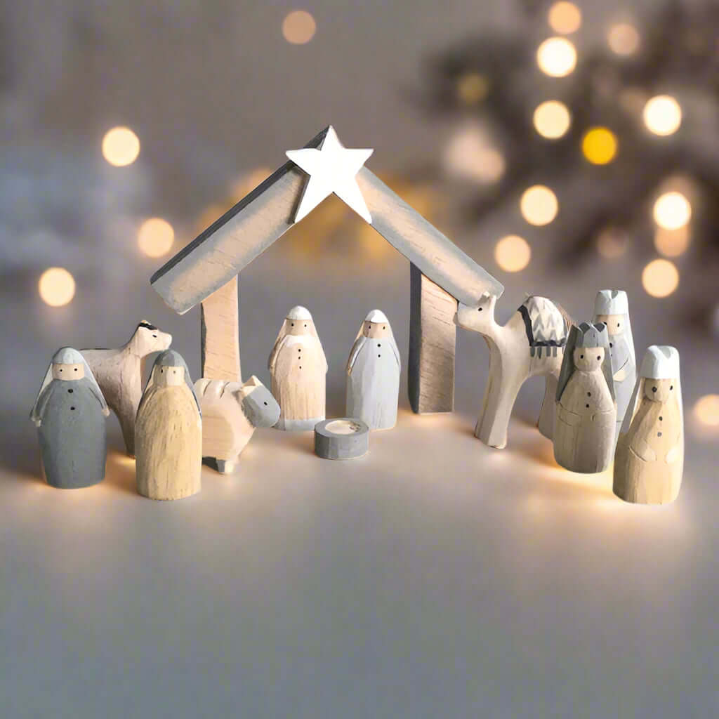 Wooden nativity set with stable and star on a light gray background