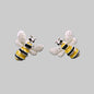 Bee-shaped earrings on a gray stone surface