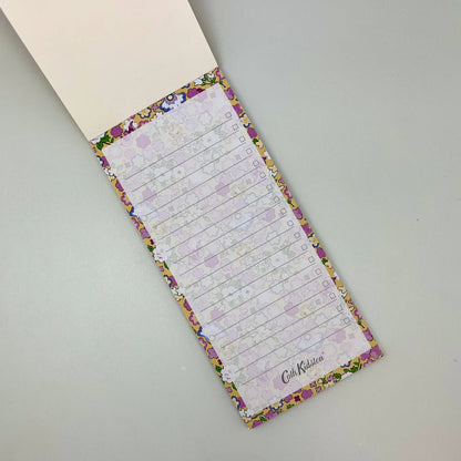 Floral-patterned notepad with checklists on a gray surface