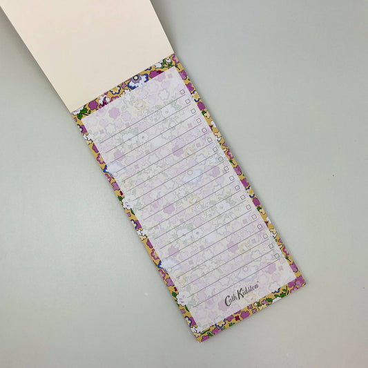 Floral-patterned notepad with checklists on a gray surface