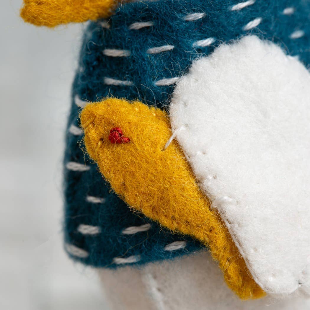Close-up of a felted fabric with blue, yellow, and white colors on a blurred background