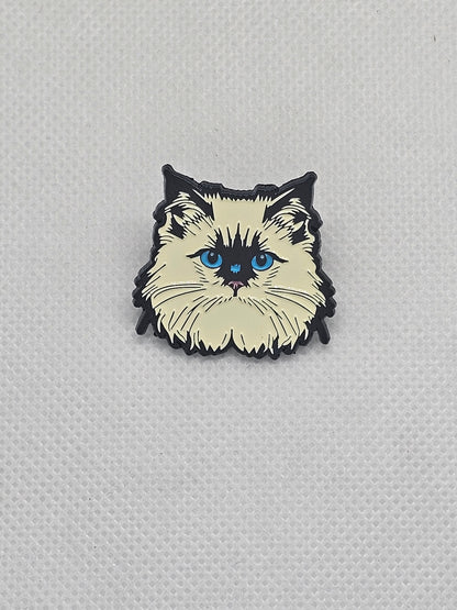 Enamel pin badge featuring a fluffy cat design with blue eyes, perfect for pet lovers.