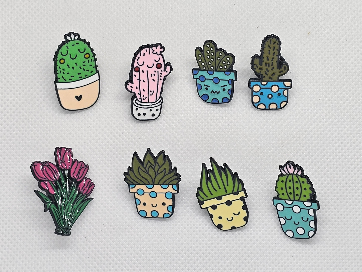 Colorful enamel pin badges featuring cute cacti and flowers in pots, perfect for accessories or gifts.