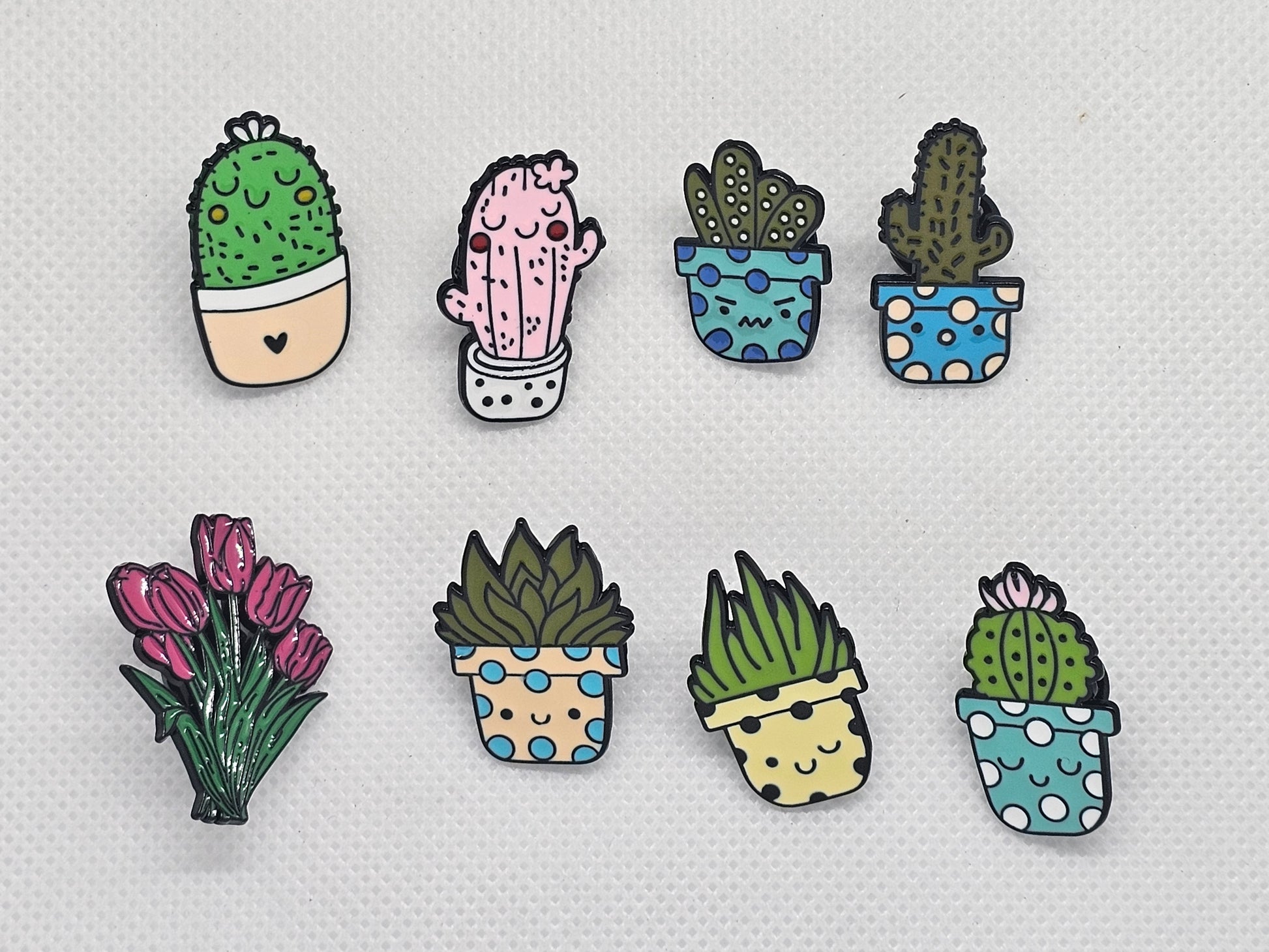 Colorful enamel pin badges featuring cute cacti and flowers in pots, perfect for accessories or gifts.